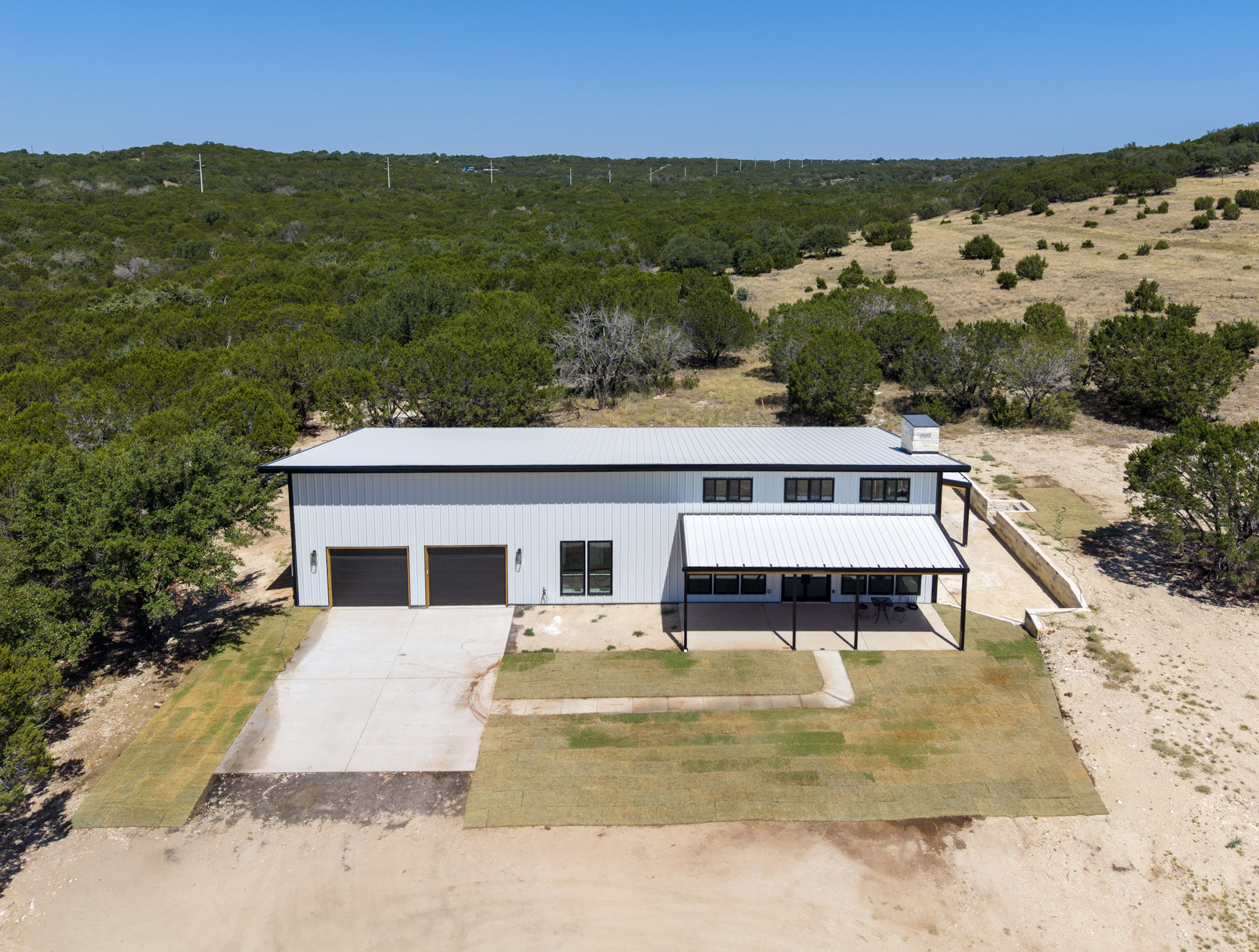 Barndominium with the shop end and the living end under one roof, covered patio and lawn