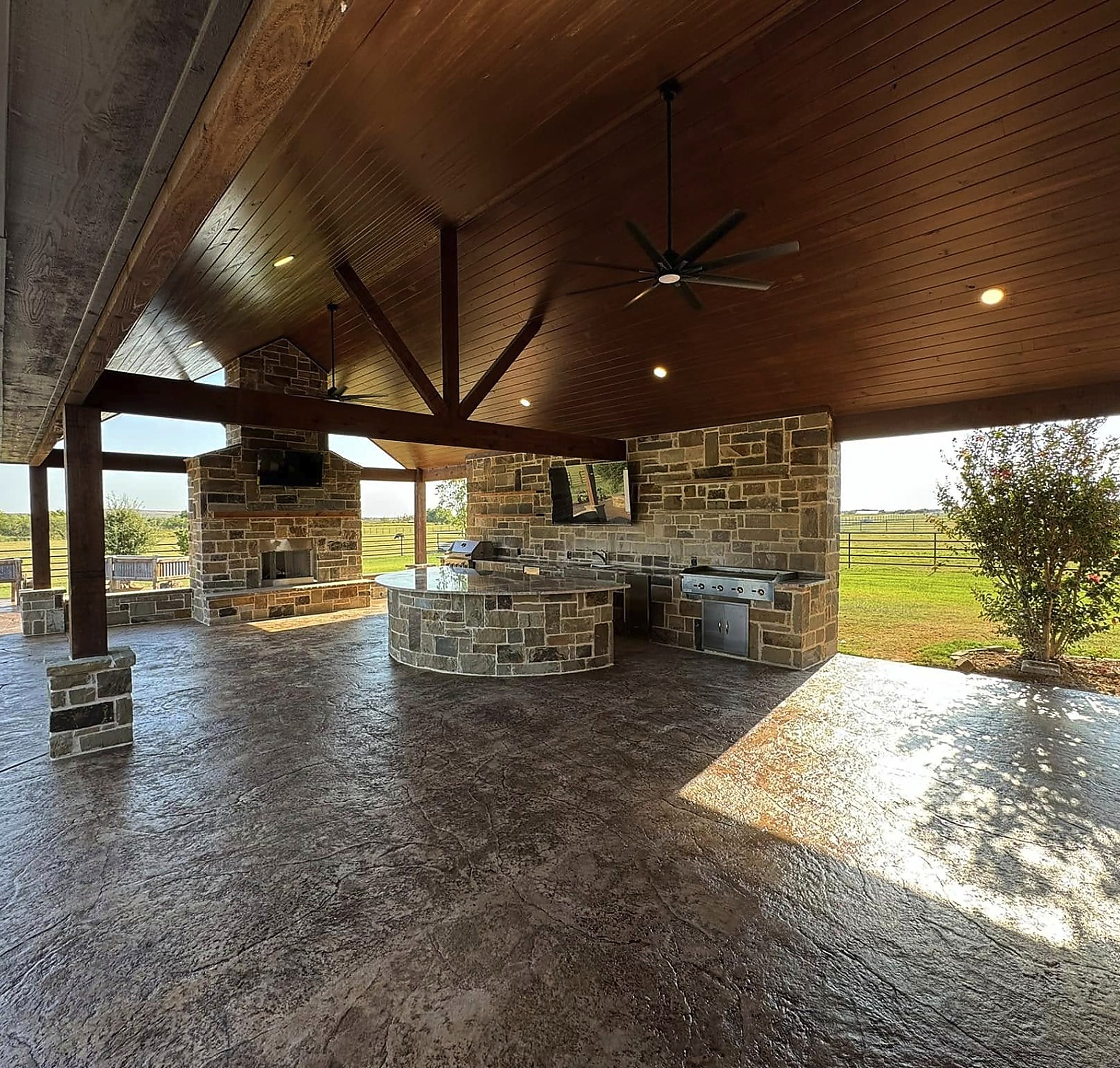 Covered pavilion and stone kitchen opening onto open pasture